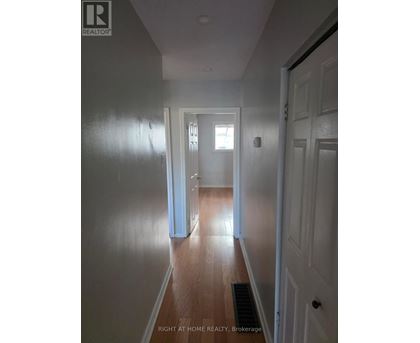 A hallway with a door on the right and a window on the left.