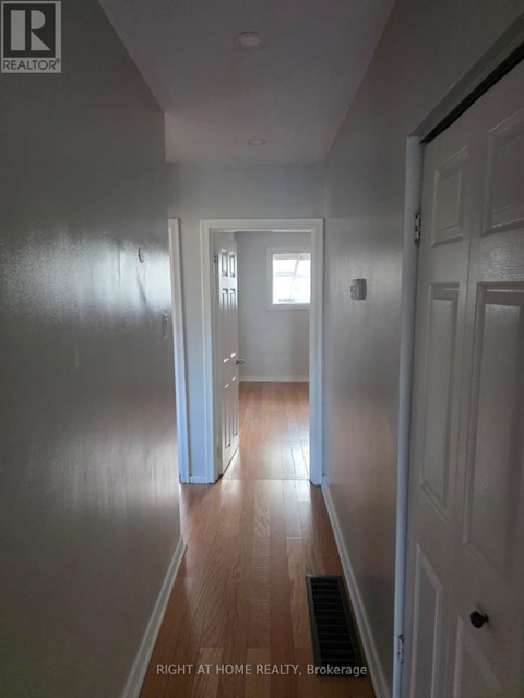 A hallway with a door on the right and a window on the left.