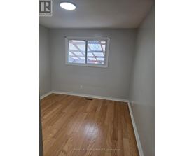 A room with wooden flooring and a window.