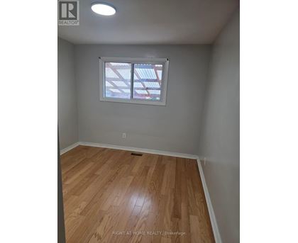 A room with wooden flooring and a window.