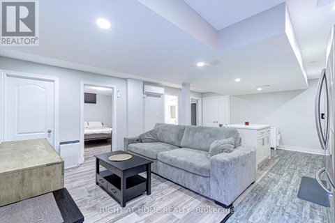 A living room with a grey couch and a black coffee table.