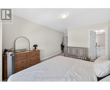 A bedroom with a white bed, a dresser, and a mirror.
