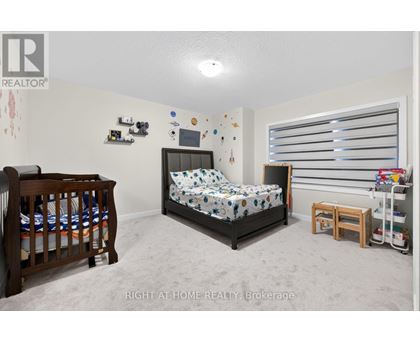 A bedroom with a bed, a crib, and a window with blinds.