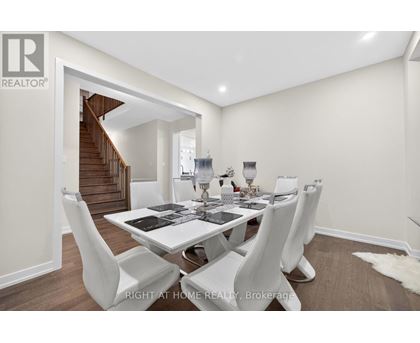 A dining room with a white table and chairs.