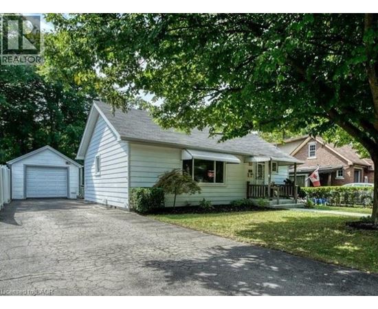 A house with a garage is surrounded by trees.