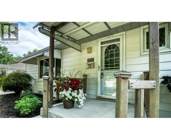 A house with a porch and a sign that says "REALTOR".