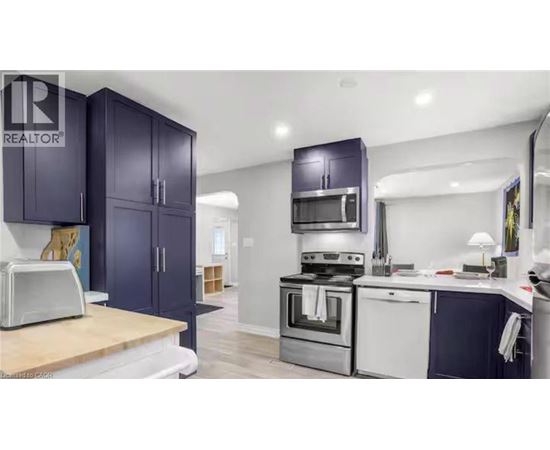 A kitchen with dark blue cabinets and stainless steel appliances.
