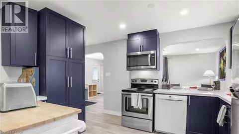 A kitchen with dark blue cabinets and stainless steel appliances.