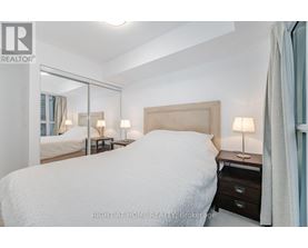 A bedroom with a large bed and a mirror on the wall.