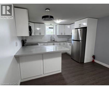 A kitchen with white cabinets and a stainless steel refrigerator.