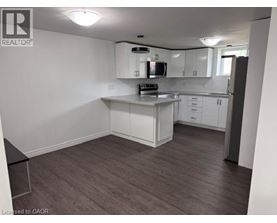 A kitchen with white cabinets and a black countertop.
