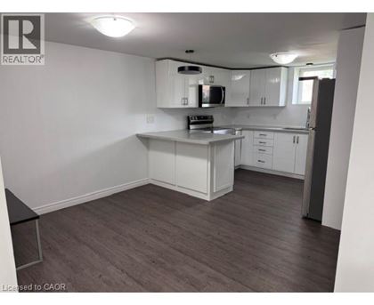 A kitchen with white cabinets and a black countertop.