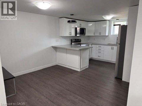 A kitchen with white cabinets and a black countertop.