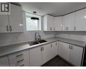 A kitchen with white cabinets and a window above the sink.