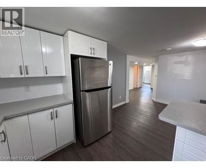 A kitchen with white cabinets and a stainless steel refrigerator.