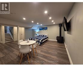 A bedroom with a bed, a table and chairs, and a television.