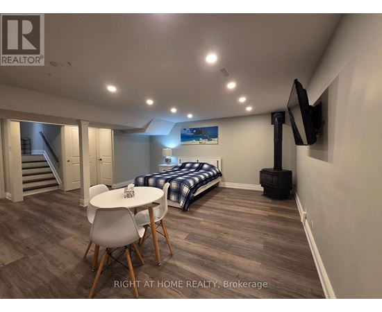 A bedroom with a bed, a table and chairs, and a television.