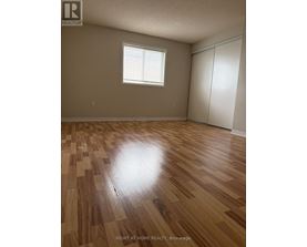 A room with wooden flooring and a window.