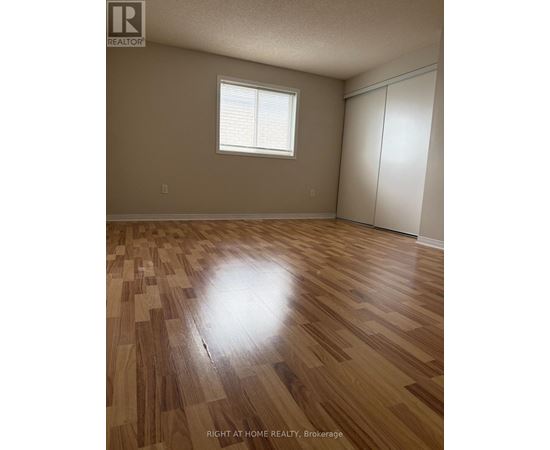 A room with wooden flooring and a window.