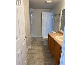 A bathroom with a toilet, sink, and shower.