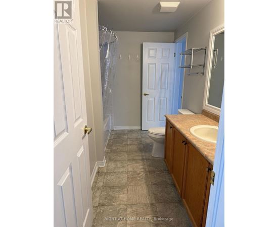 A bathroom with a toilet, sink, and shower.