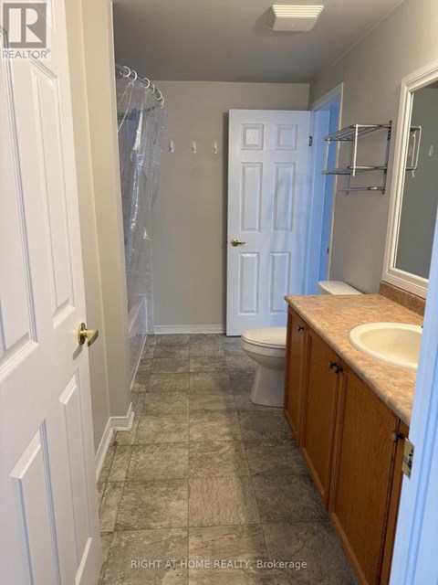 A bathroom with a toilet, sink, and shower.