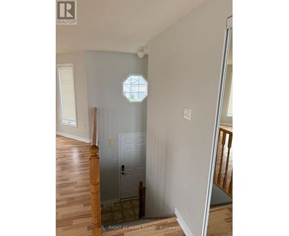 A white door is in a room with wooden floors and a window.