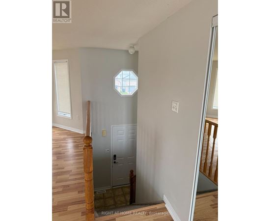 A white door is in a room with wooden floors and a window.