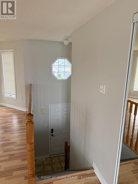 A white door is in a room with wooden floors and a window.