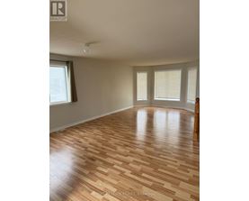 A room with wooden flooring and a window.