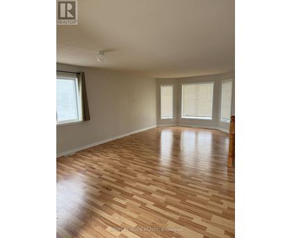 A room with wooden flooring and a window.