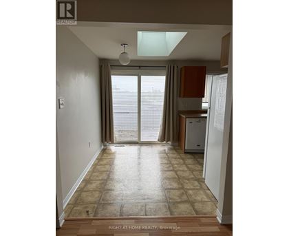 A room with a tiled floor and a window with blinds.