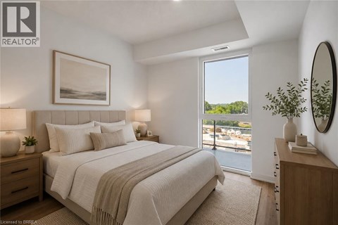 A bedroom with a large bed and a view of the outside through a sliding glass door.