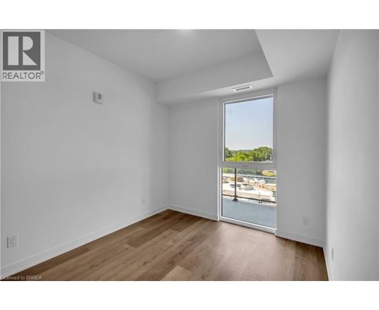 A room with a view of a marina through a sliding glass door.