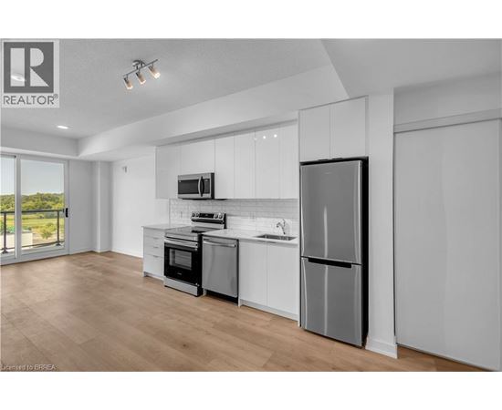 A modern kitchen with white cabinets and stainless steel appliances.