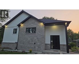 A modern house with a black door and windows is shown.