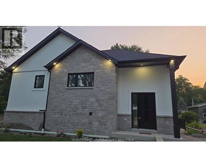 A modern house with a black door and windows is shown.