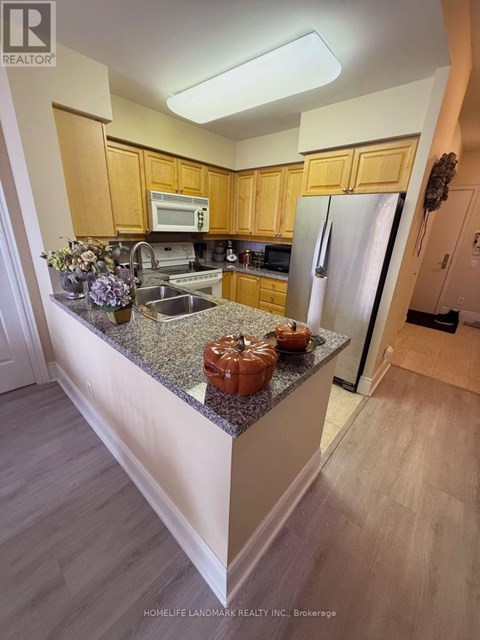 A kitchen with wooden cabinets and granite countertops.