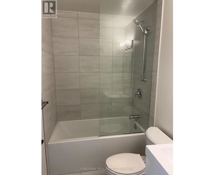 A white toilet sits next to a glass shower stall.