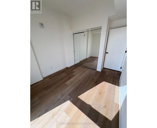 A room with wooden flooring and white walls.