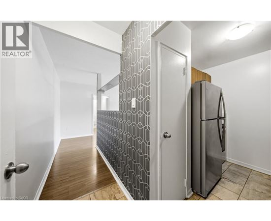 A modern kitchen with a refrigerator and a patterned backsplash.