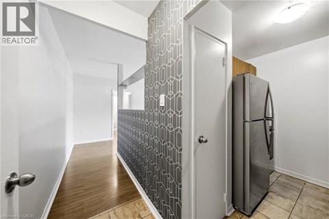 A modern kitchen with a refrigerator and a patterned backsplash.