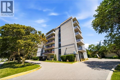 A modern apartment building with a well-maintained lawn in front.
