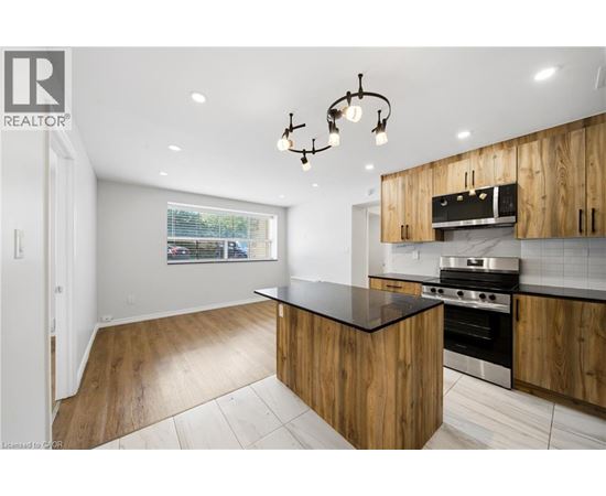 A modern kitchen with wooden cabinets and a black countertop.