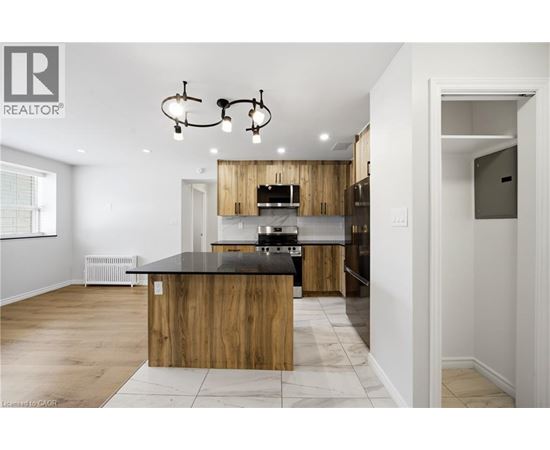 A modern kitchen with wooden cabinets and a black countertop.