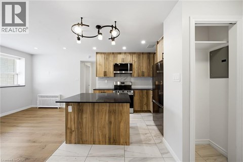 A modern kitchen with wooden cabinets and a black countertop.