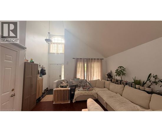 A living room with a white couch and a wooden cabinet.