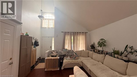 A living room with a white couch and a wooden cabinet.