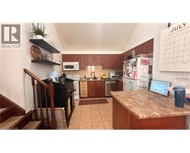 A kitchen with a counter top and a calendar on the wall.