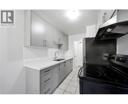 A modern kitchen with white cabinets and black appliances.